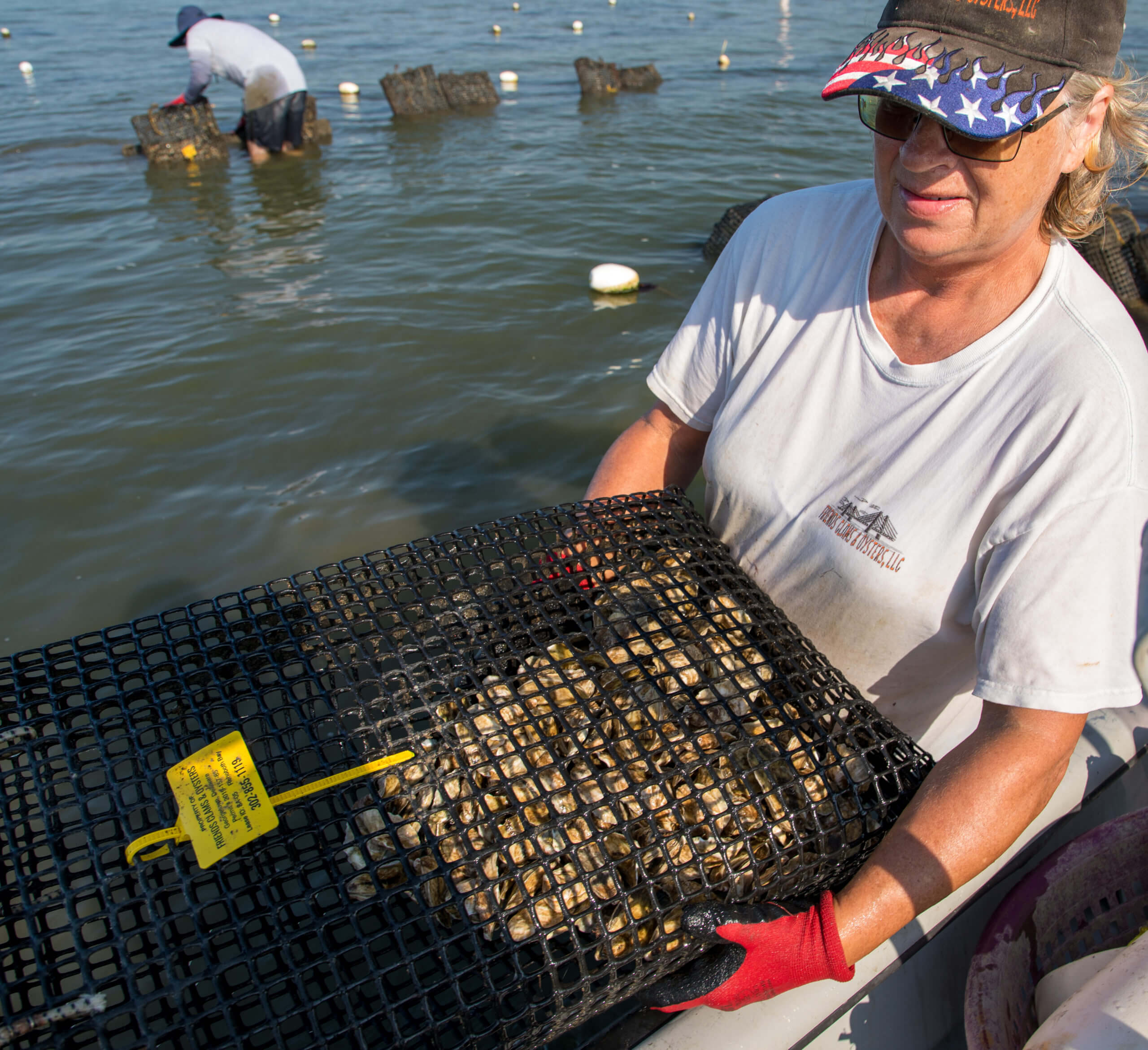 woman holding cage full of oysters
