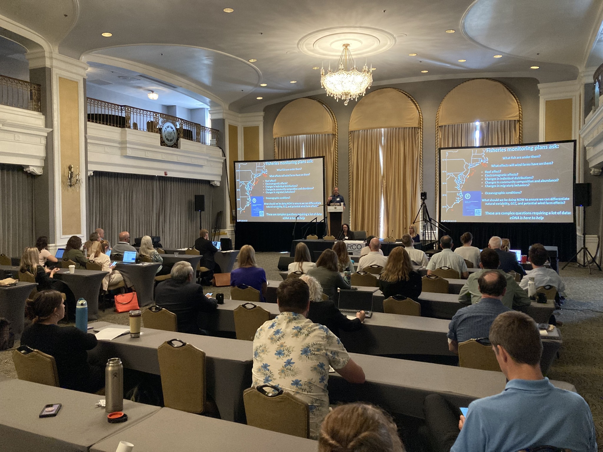 Audience members listen to a presentation